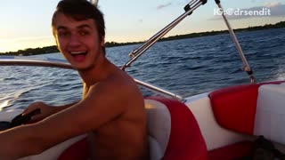 Guy jumps off red and white speed boat