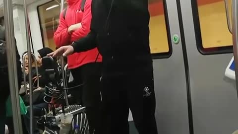 Guy on a subway train singing karaoke