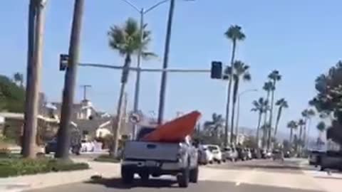 Giant orange kayak in grey truck