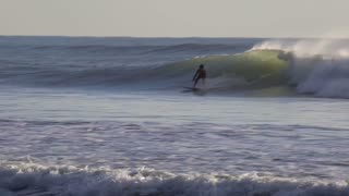 Surfers riding Atlantic Ocean waves at Cabedelo, Viana do Castelo, Portugal in January 2024