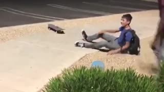 Two kids on skate boards trip over same sidewalk