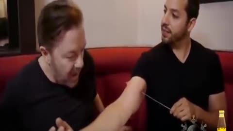 David Blaine confuses Ricky Gervais with a needle in his arm.