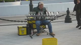 Street performer amazingly plays music on water glasses