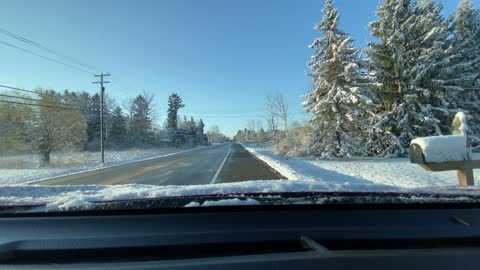 Car With Snowy Windshield on Wrong Side of Road