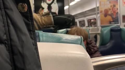 Woman sits upside down feet in the air on subway train