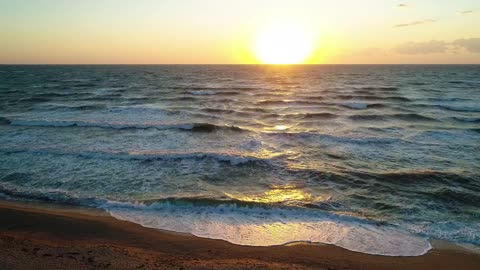 Waves in the sea from a beach during a sunset