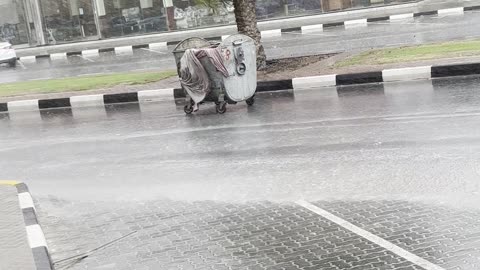 Garbage Drum Floats Down Street In Heavy Rain
