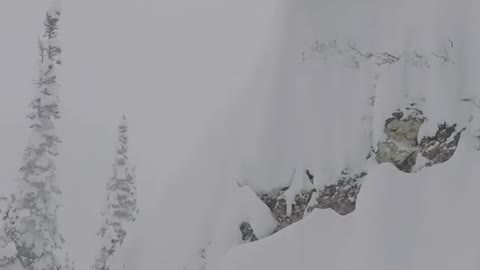 WHERE DID HE GO? Dude skis off high ledge into deep snow.