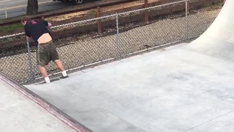 Guy black shirt skateboarding weirdly with skateboard