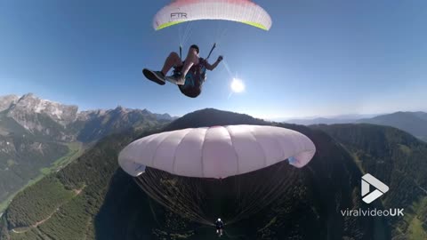 Paraglider 'stands' on top of another daredevil's parachute
