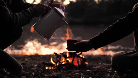 -people-pouring-a-warm-drink-around-a-campfire-513-medium