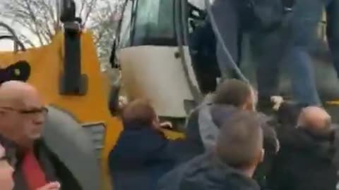 The excavator is trying to break through a crowd of protesters