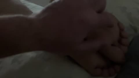 Tickling girlfriend feet while playing on phone