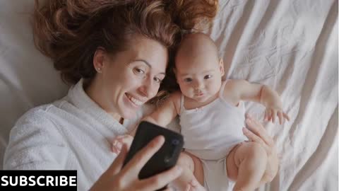 Mother and her baby daughter are making selfie or video call to father in bed