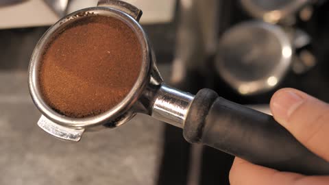 tamping coffee for a coffee maker