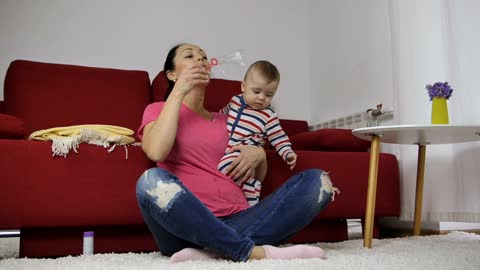 Mother blowing bubbles with her baby