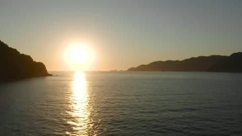 Sunset seen at sea from a coast, aerial shot