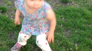Baby tries to blow on a dandelion