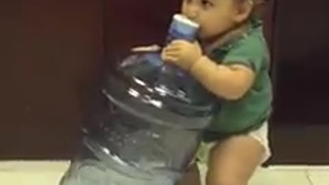 Thirsty baby tries to drink from 5 gallon water jug