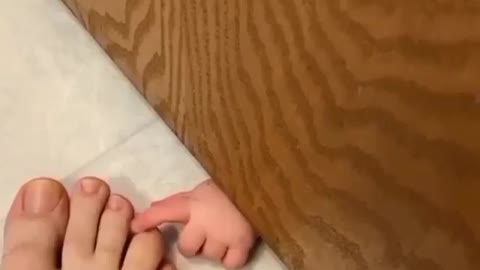 Adorable baby playing with mother's foot