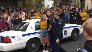 Teen girl in yellow shirt is being arrested by police, crowd chants