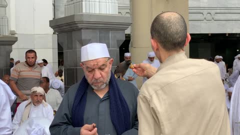 A man feeds a bird in the Great Mosque of Mecca