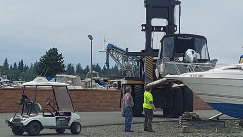 Large Marina Forklift Sets Down a Boat on Dry Dock Pads w/ Fart noise.