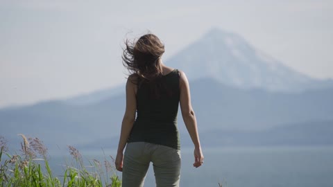 Girl Stands in a Clearing Against the Background of a Sleeping Volcano