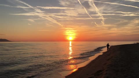 Guy running at the beach during sunset