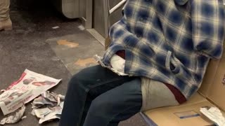 Clothes stuffed with pillows, looks like person sitting on subway, no head