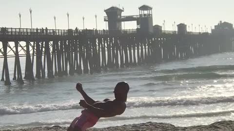 Guy pink shorts at beach doing weird dance