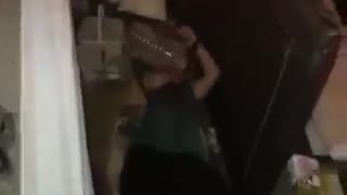 Guy green shirt tries to throw water container over his back but ends up falling backwards onto cardboard