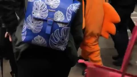 Person dressed as giant orange bird subway