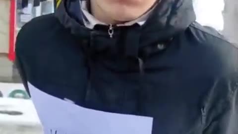 Ukriane: young man tied to poles with sign taped on jacket