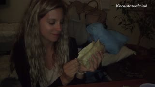 Girl shares burrito with black cat