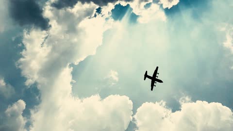 An Airplane Flying Beneath The Thick Clouds Formation In The Air