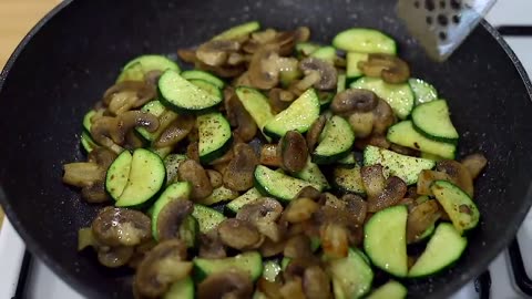 Fried potatoes with mushrooms and zucchini in a pan. An easy and delicious dinner!