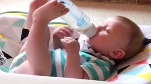 TODLER HOLDING HIS BOTTLE BY TWO LEGS.mp4