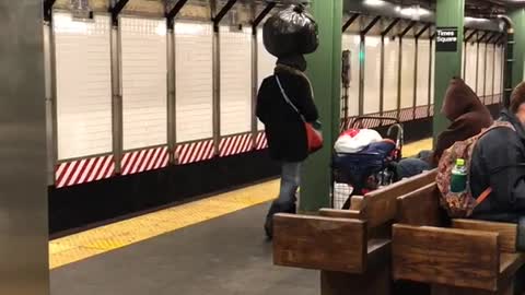 Man balancing black garbage bag on head