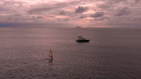 Windsurfer and a yacht in the ocean