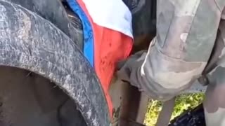 Ukrainian soldiers stepping on and tearing up a Russian flag