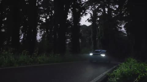 Electric car driving in the dark woods