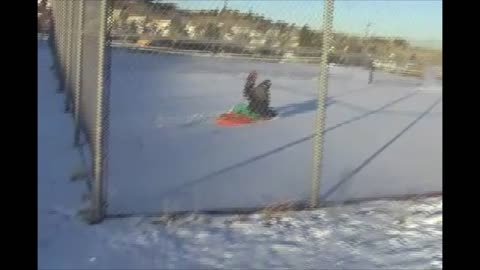 Mom And Son Amazingly Sled Through A Chain Link Fence