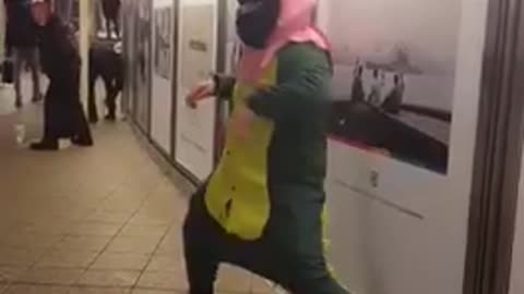 Man green dinosaur outfit dancing pink mask