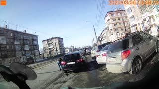 Car Grazes Woman's Shoulder in Daytime Traffic