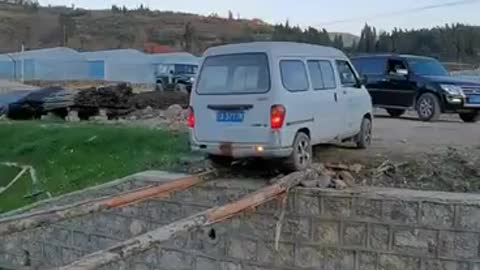 Une camionnette recule sur deux troncs d'arbres