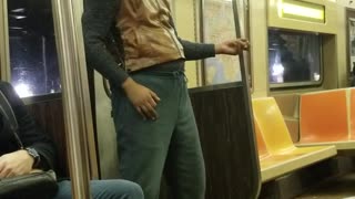 Man plays the air guitar by himself on subway train