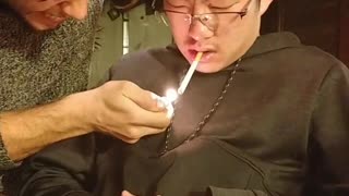 Music guy black hoodie asleep and guy lighting cigarette in mouth