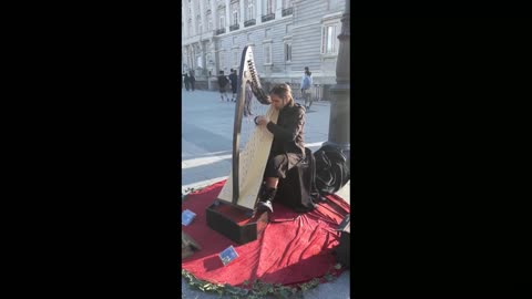 Harpist busks outside Royal Palace, Madrid, Spain