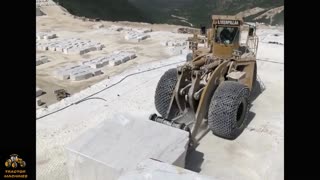 On the construction site, two forklifts are transporting huge rocks.